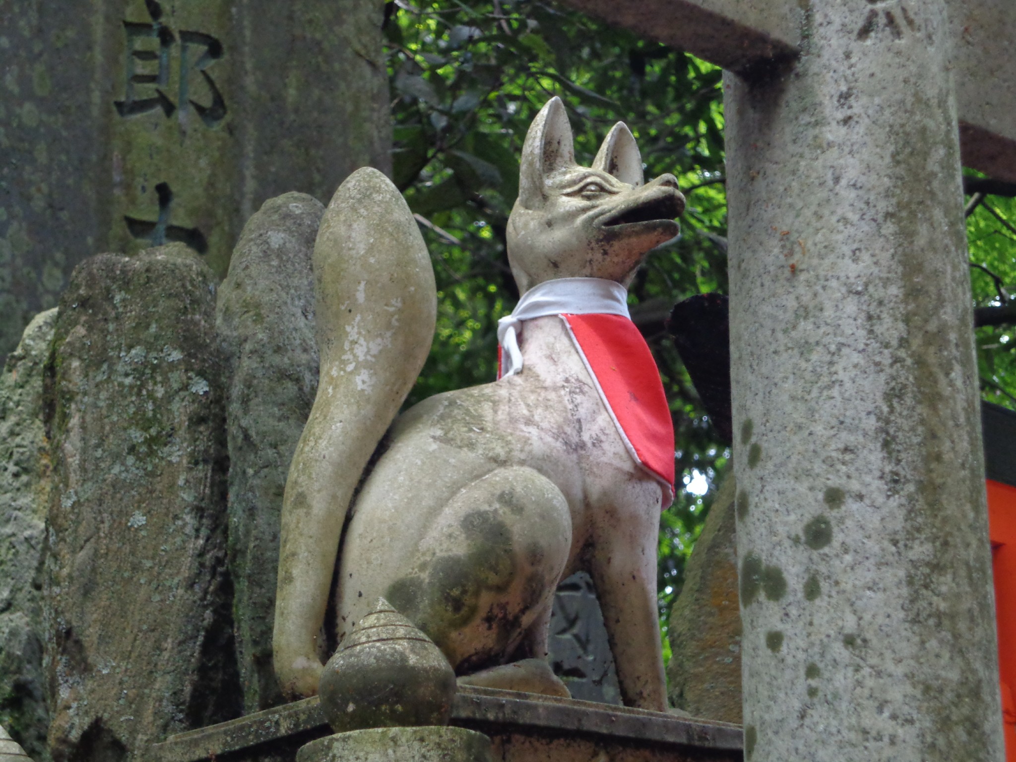 A stone fox statue holding a key in its mouth at Fushimi Inari
