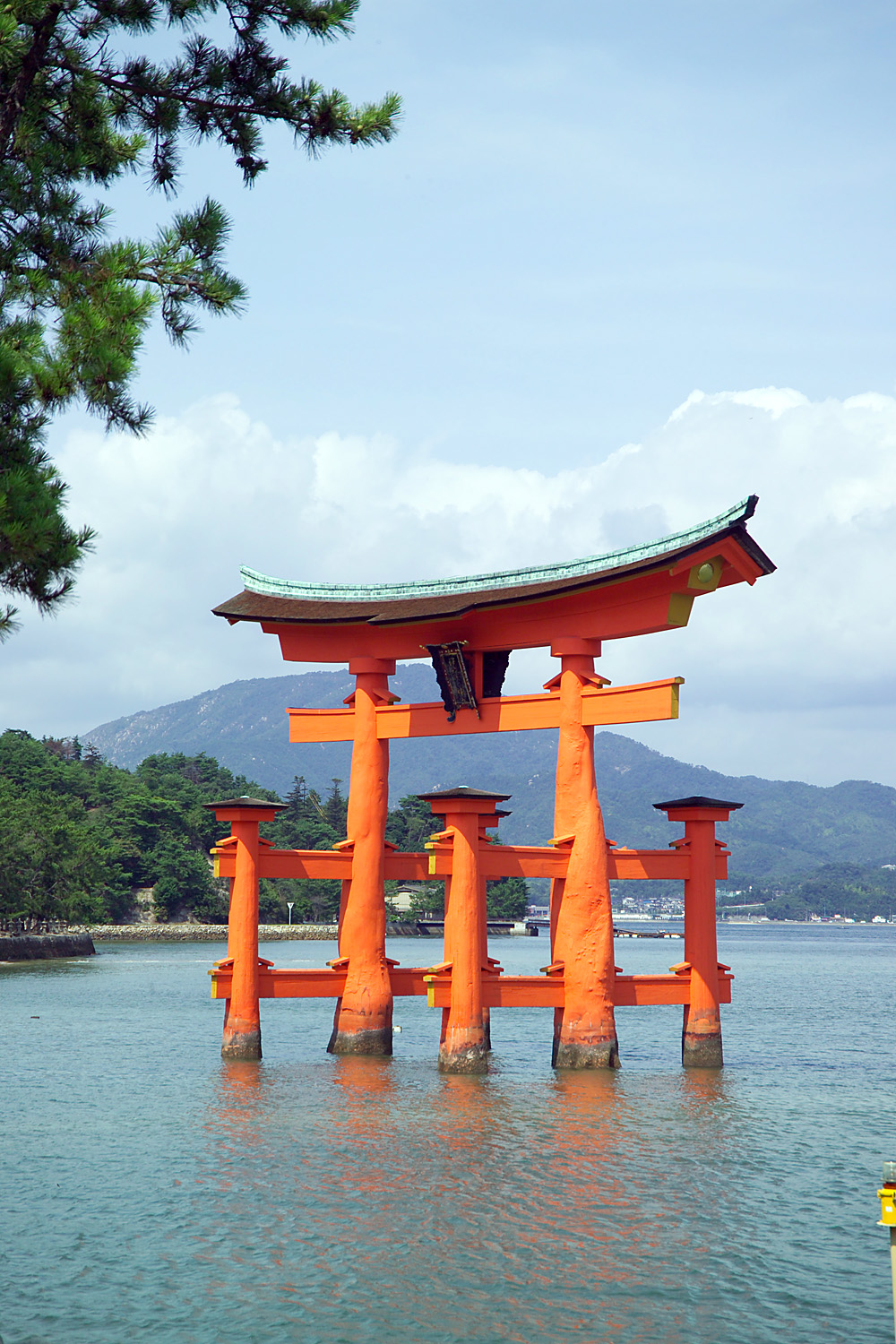 People walking on the sand to the base of the Great Torii at low tide