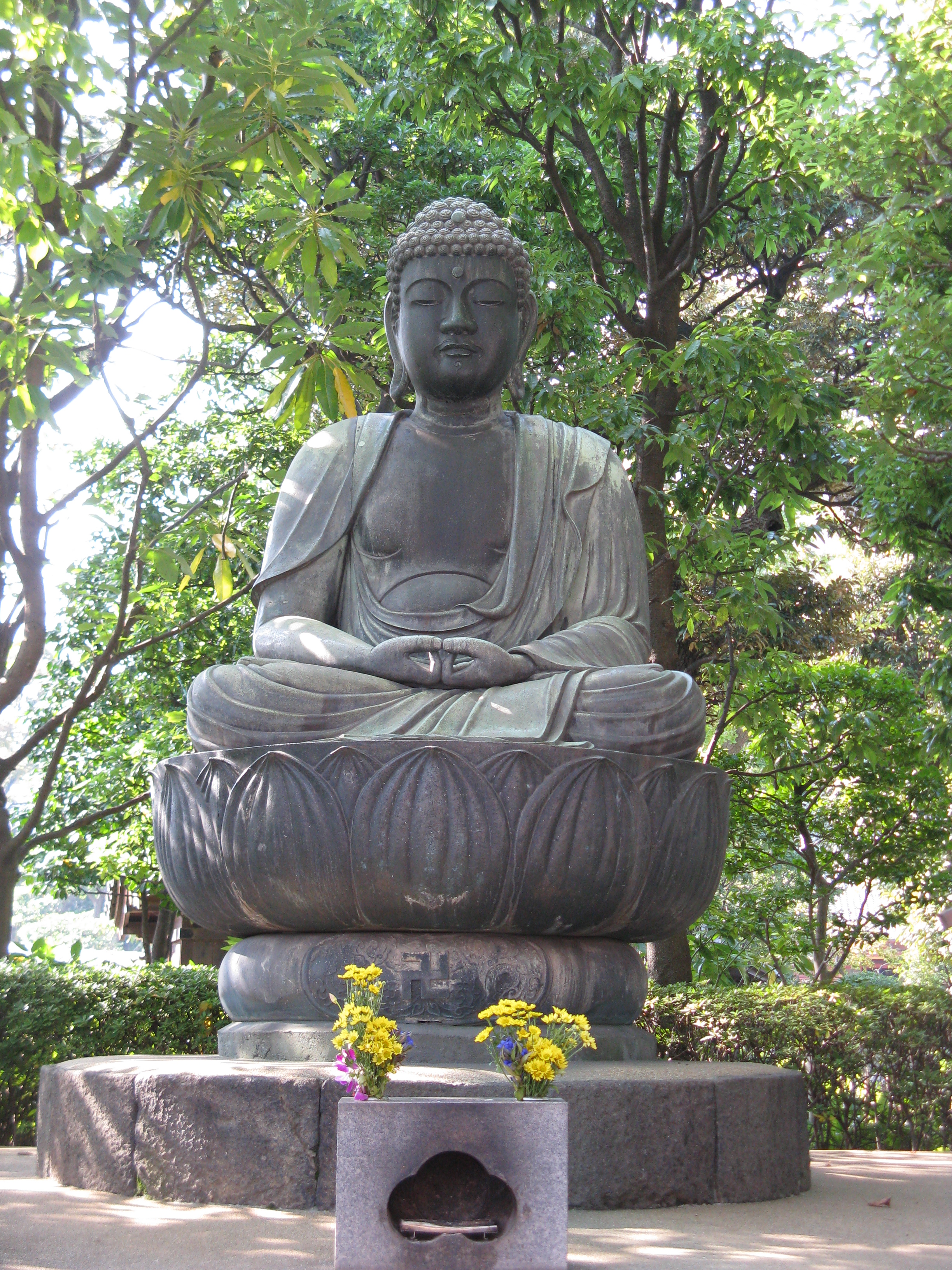 A seated Amida Nyorai showing snail-shell curls and a plain robe