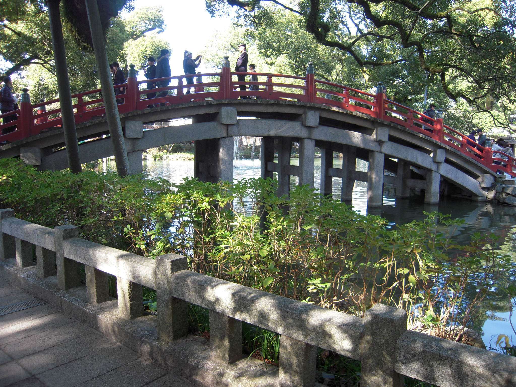 The arched red taiko drum bridge crossing Shinji pond at Dazaifu Tenmangu