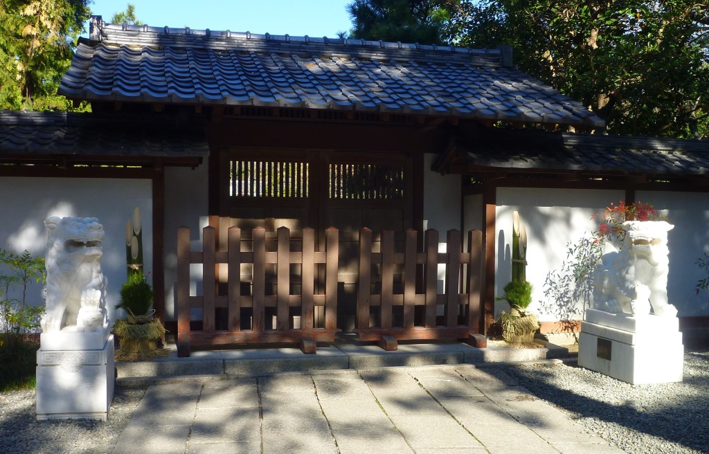 A pair of kadomatsu New Year decorations of pine and bamboo standing in front of a gate in Kamakura