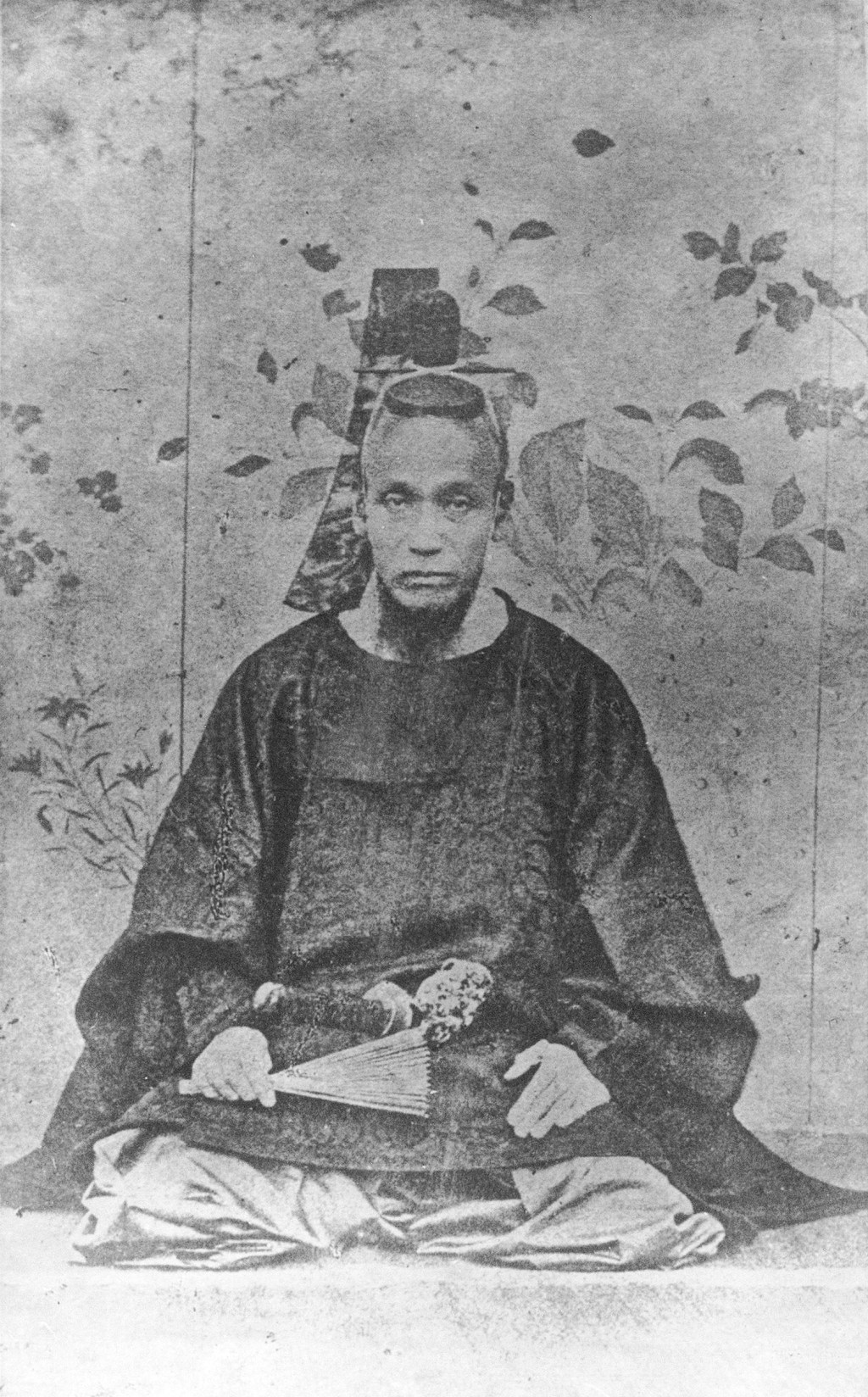 Black-and-white portrait photograph of Shima Yoshitake in formal court dress, wearing a short sword